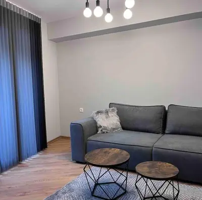 a living room with a blue couch and two tables at 7Mins City Garden and Center+P in Plovdiv