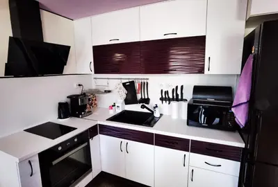 a kitchen with white cabinets and a black refrigerator at Апартамент 204 Студенец in Pamporovo