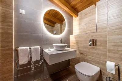 a bathroom with a sink and a toilet and a mirror at Pirin Golf Hotel&Spa Apartment 17 - private luxury apartment in Razlog