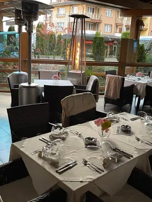 a white table with utensils on it in a restaurant at Pirin Golf Hotel&Spa Apartment 17 - private luxury apartment in Razlog