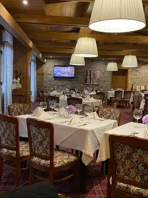 a dining room with white tables and chairs and lights at Pirin Golf Hotel&Spa Apartment 17 - private luxury apartment in Razlog