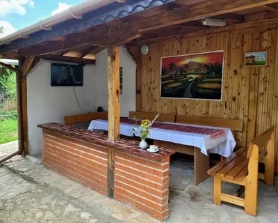 a wooden room with a bed and a bench at Вила Виктория in Chekhlare