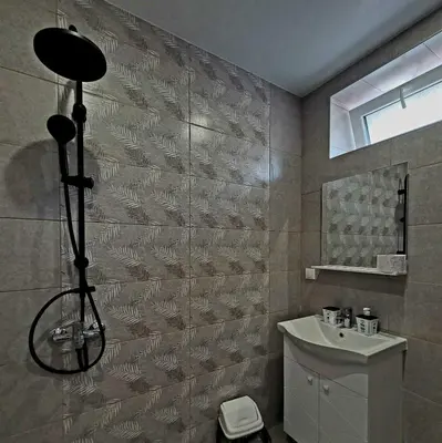 a bathroom with a shower and a sink and a toilet at Вила Виктория in Chekhlare