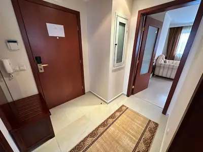 a hallway with a wooden door and a rug at Downtown apartments in Bansko