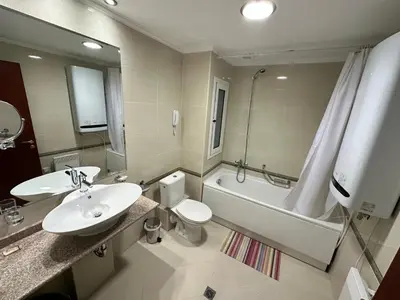 a bathroom with a sink and a toilet and a tub at Downtown apartments in Bansko