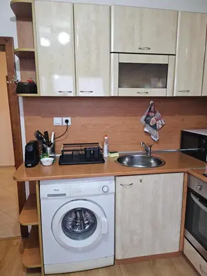 a kitchen with a washing machine and a sink at Апартамент Радост in Bansko