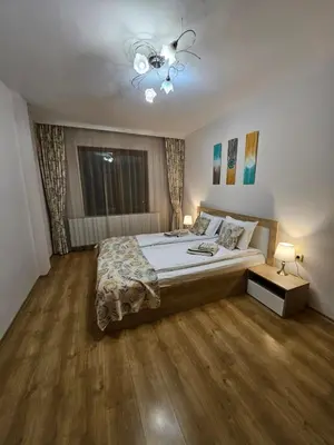 a bedroom with a bed and a ceiling fan at Апартамент Радост in Bansko