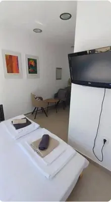 a room with two beds and a flat screen tv at BohoBox Studios in Plovdiv