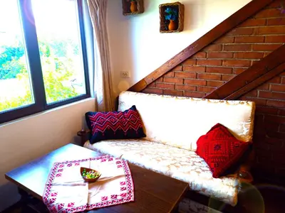 a room with a bench and a table with pillows at Ethno art maisonette in the center of Sofia - plus Free Vouchers & Gift in Sofia