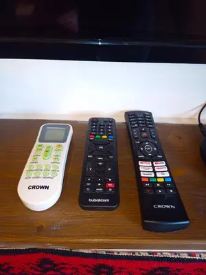 two remote controls and a cell phone on a table at Ethno art maisonette in the center of Sofia - plus Free Vouchers & Gift in Sofia
