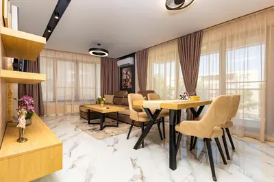 a living room with tables and chairs and windows at Urban Lux Apartments Center of Plovdiv by Flat Mаnager in Plovdiv