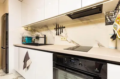 a kitchen with white cabinets and a black appliance at Urban Lux Apartments Center of Plovdiv by Flat Mаnager in Plovdiv