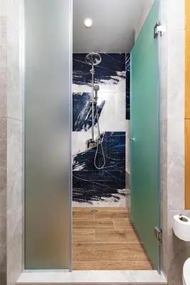 a bathroom with a shower with a painting on the wall at Urban Lux Apartments Center of Plovdiv by Flat Mаnager in Plovdiv