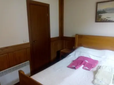 a bedroom with a bed with a pink robe on it at Pirin Golf - NIRVANA, Studio&SPA in Razlog