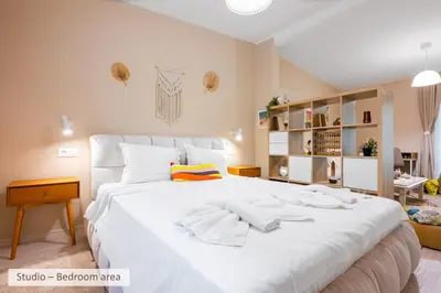 a bedroom with a large white bed with towels on it at Super Central Stylish Suite & Studio with Shared Terrace by Flat Mаnager in Sofia