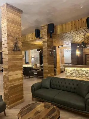 a living room with a couch and a stone wall at Grand resort luxury apartment in Pamporovo