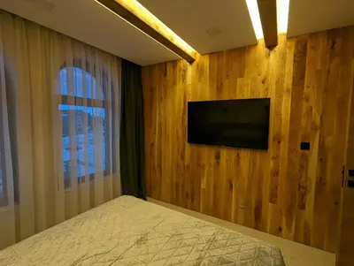 a bedroom with a television on a wooden wall at Pine & Wine Sauna Apartment in Pamporovo
