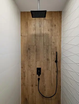 a bathroom with a wooden wall with a black electrical outlet at Pine & Wine Sauna Apartment in Pamporovo