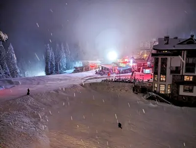 a ski resort at night with snow and lights at Pine & Wine Sauna Apartment in Pamporovo