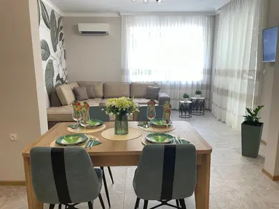 a living room with a wooden table and chairs at SP Urban Apartment in Plovdiv