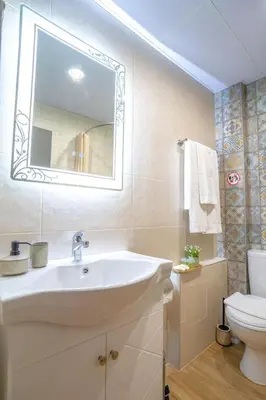 a bathroom with a sink and a toilet and a mirror at SP Urban Apartment in Plovdiv