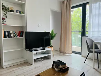 a living room with a flat screen tv on a white stand at Classic Modern Apartment with Parking Place in Sofia