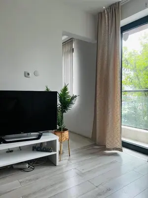 a living room with a flat screen tv on a white cabinet at Classic Modern Apartment with Parking Place in Sofia
