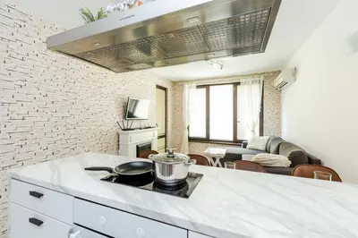 a kitchen with a stove and a living room at The White Apartment 3BR - free parking in Sofia
