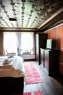a bedroom with a bed and a television and windows at Къща ЕТНО in Koprivshtitsa