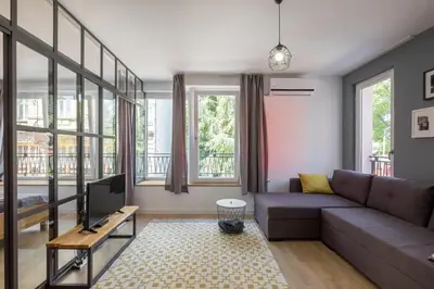 a living room with a couch and a tv at Industrial Look Apartment Top Centre + Free Parking in Sofia
