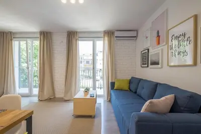 a living room with a blue couch and a table at Quiet & airy modern apt. Top Centre Free Parking in Sofia