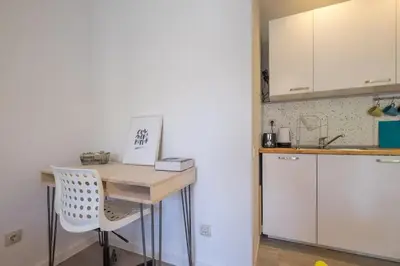 a kitchen with a wooden table and a white refrigerator at Quiet & airy modern apt. Top Centre Free Parking in Sofia