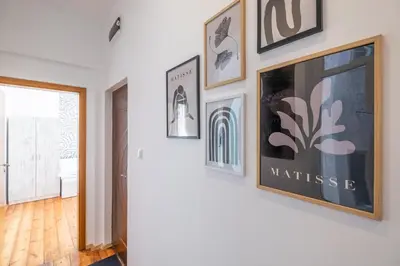 a hallway with framed art on a wall at Blue house Sofia Top Center 3BDR family & friends in Sofia