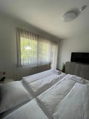 a bedroom with two white beds and a window at Апартамент Никола и Мария in Sapareva Banya