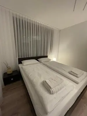a bedroom with a white bed with towels on it at Апартамент Никола и Мария in Sapareva Banya