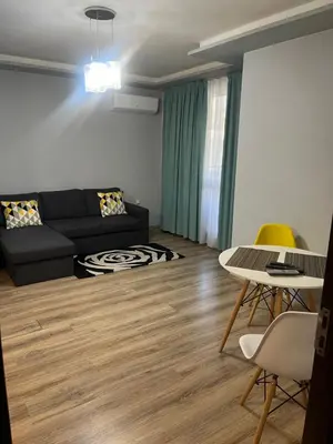 a living room with a black couch and a table at Guest House Amaya Med in Plovdiv
