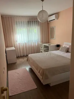 a bedroom with two beds and a desk and a window at Guest House Amaya River in Plovdiv