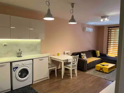 a kitchen and living room with a table and a washing machine at Guest House Amaya River in Plovdiv