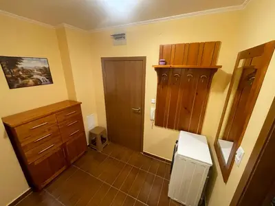 a bathroom with a wooden cabinet and a door at Ski-in ski-out Fantastic Apartament in Bansko