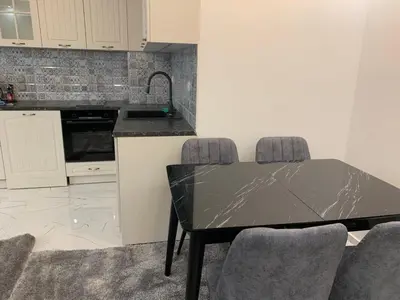 a kitchen with a black table and some chairs at Top Central Apartment & Free Parking in Sofia