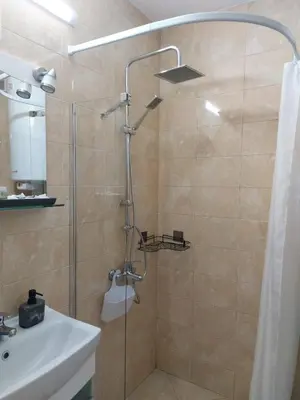a shower with a glass door next to a sink at Studio John's in Blagoevgrad