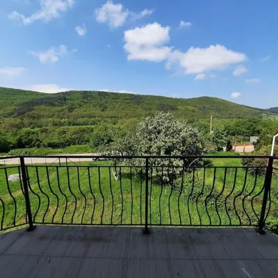 a balcony with a view of a field and a tree at 