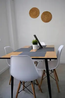 a dining room table with white chairs and a laptop at Modern City Center 2 Bedroom Apartment in Sofia