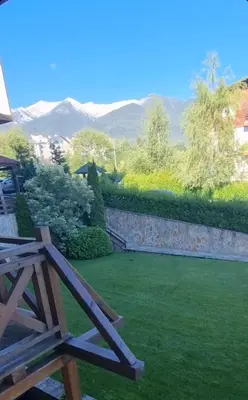 a picnic table in a garden with mountains in the background at Green life, Bansko, private studio c-17 in Bansko