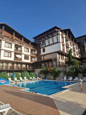 a hotel with a swimming pool in front of a building at Green life, Bansko, private studio c-17 in Bansko