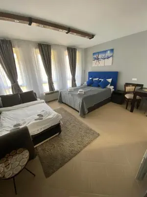 a large bedroom with two beds and a table at Green life, Bansko, private studio c-17 in Bansko