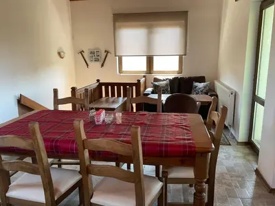 a dining room with a table and chairs and a couch at Three Graces in Banya