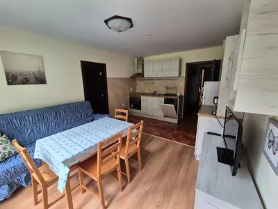 a kitchen and dining room with a table and a couch at Elit Pamporovo Accommodation in Pamporovo