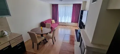 a living room with a table and a pink couch at Elit Pamporovo Accommodation in Pamporovo