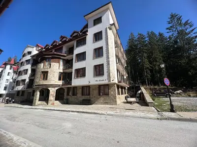 a large building on the side of a street at Minkov Apartments, Пампорово - Замъка 2 in Pamporovo
